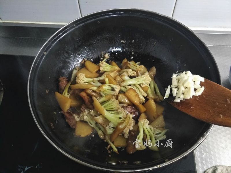 土豆烧菜花的做法操作步骤第9步：中途翻面，汤汁少许时加入蒜末提味，关火出锅
