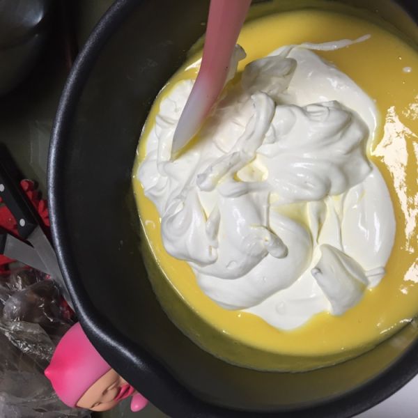 芒果慕斯蛋糕的做法操作步骤第7步：奶油打发，不需要太硬，打发就行，倒入芒果糊，搅拌均匀