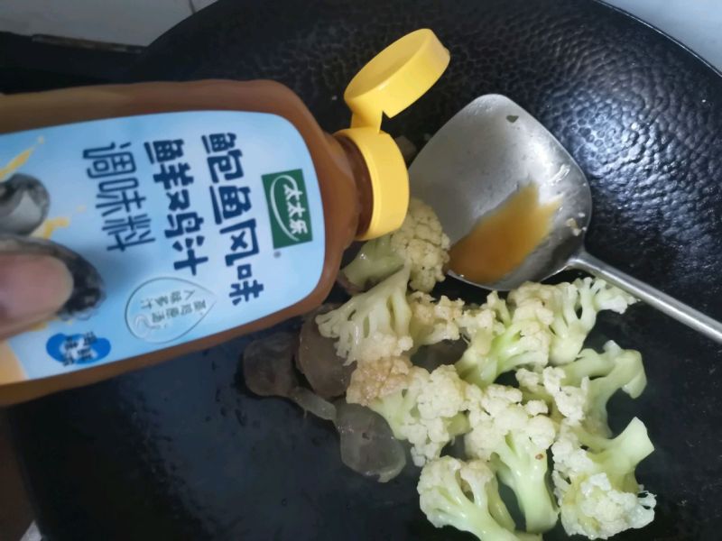 腊肠炒菜花的做法操作步骤第6步：加点盐，放入太太乐鲍鱼鲜鸡汁炒均匀