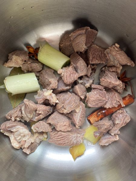 红烧羊肉炖胡萝卜土豆的做法操作步骤第3步：高压锅中放入洗净的羊肉，加入葱段姜片八角香叶桂皮