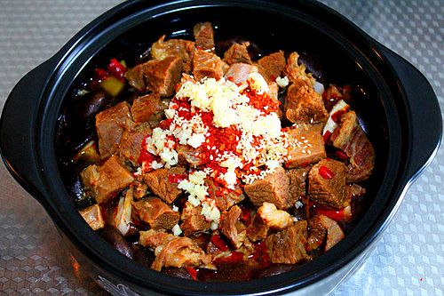 牛肉火锅的做法操作步骤第10步：将干辣椒面、蒜末、白芝麻放在牛肉上面。