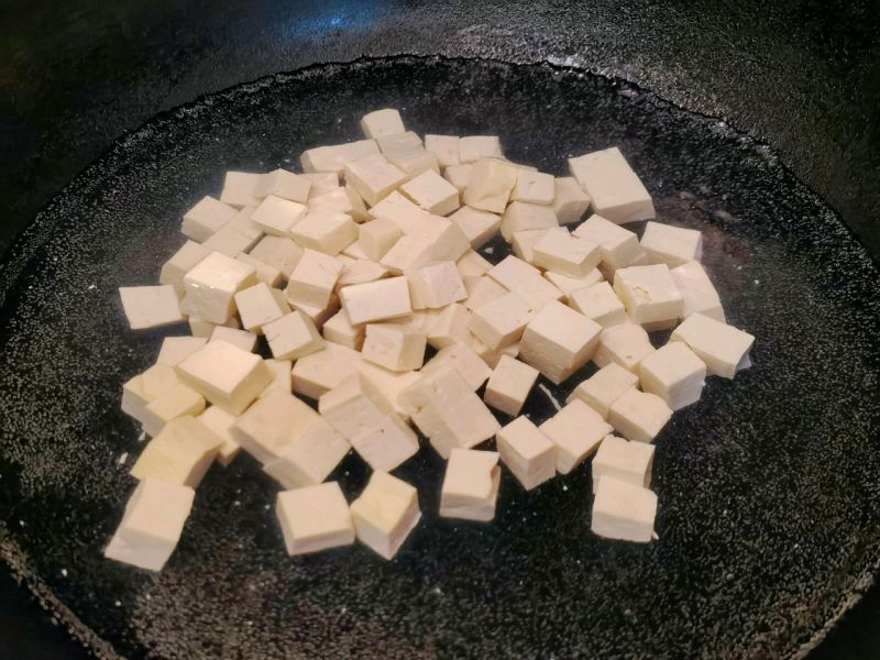 香椿拌豆腐的做法操作步骤第5步：豆腐均匀切小块，焯水1分钟
