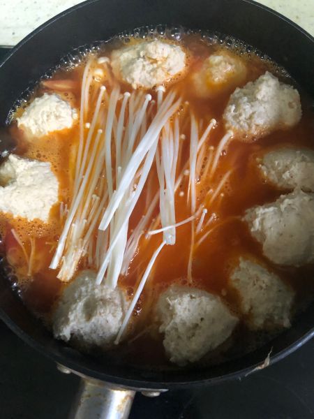 番茄鸡胸肉丸子汤的做法操作步骤第14步：再次煮开时放入金针菇和鸡肉丸