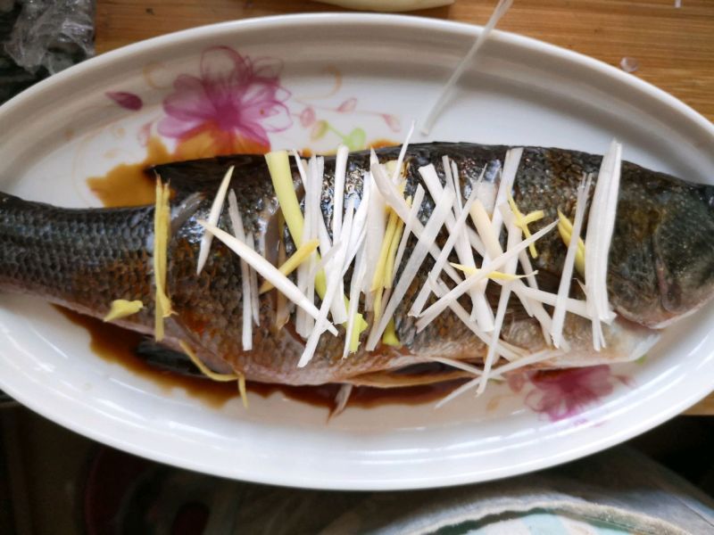 清蒸鲈鱼的做法操作步骤第6步：鱼上再放上姜丝和葱白
