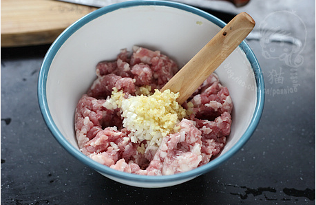 冬瓜汆丸子汤的做法操作步骤第3步：在肉馅中放入葱姜米，再用木棒一边搅匀一边捣，这样还可以把姜米再碾得细碎一点。