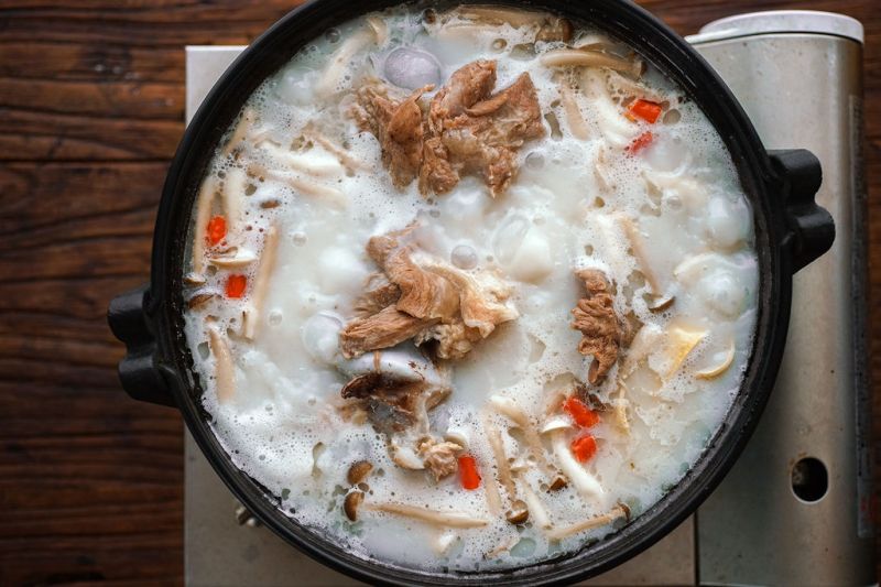 骨汤火锅的做法操作步骤第2步：汤底中可加入两小勺牛奶使其更浓稠。适量盐调味，放入厚百叶和各种菌菇继续煮至食材变熟。