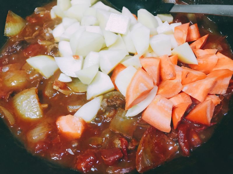 红烩牛肉的做法操作步骤第9步：放入土豆胡萝卜炖煮