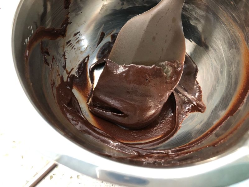 雪顶咖啡的做法操作步骤第5步：隔水加热巧克力，加一些淡奶油，做甘纳许