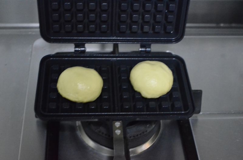 淡奶油华夫饼（发酵版）的做法操作步骤第6步：取2个小面团放在模具中央按压定位，合上饼模小火烘烤，大约每一面1分钟左右，，中间可以打开看看烧色程度。