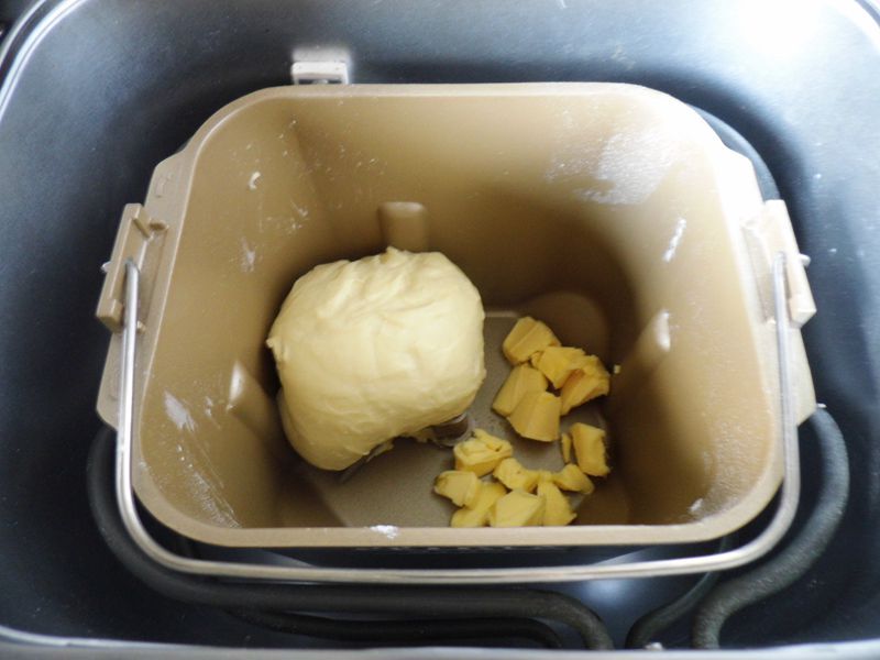 椰蓉面包的做法操作步骤第3步：加入软化的黄油35克，再次和面20分钟，面团光滑而充满弹性