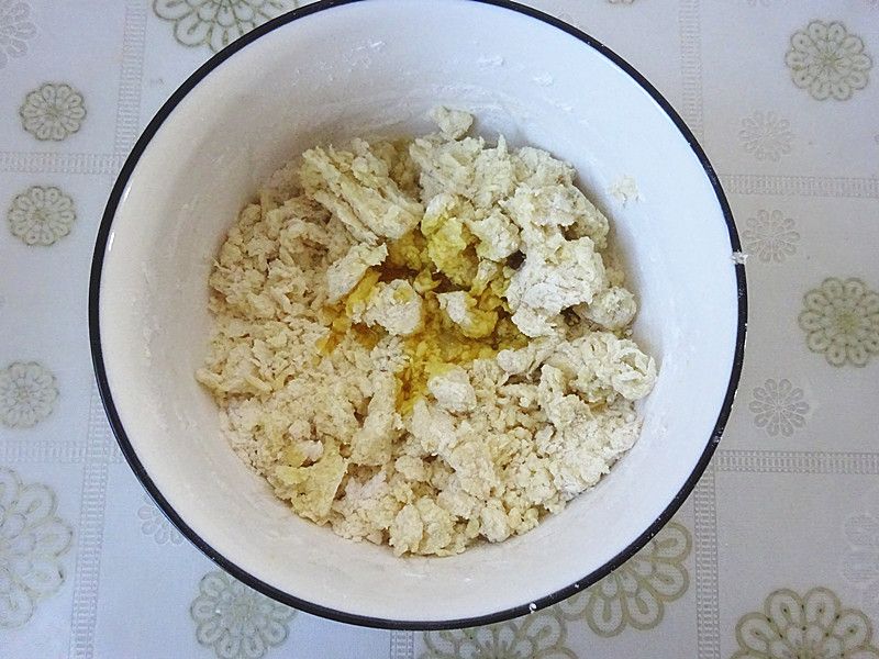 红薯小点心的做法操作步骤第4步：在把红薯泥和面粉等搅拌成大絮状的时候，放入玉米油。
