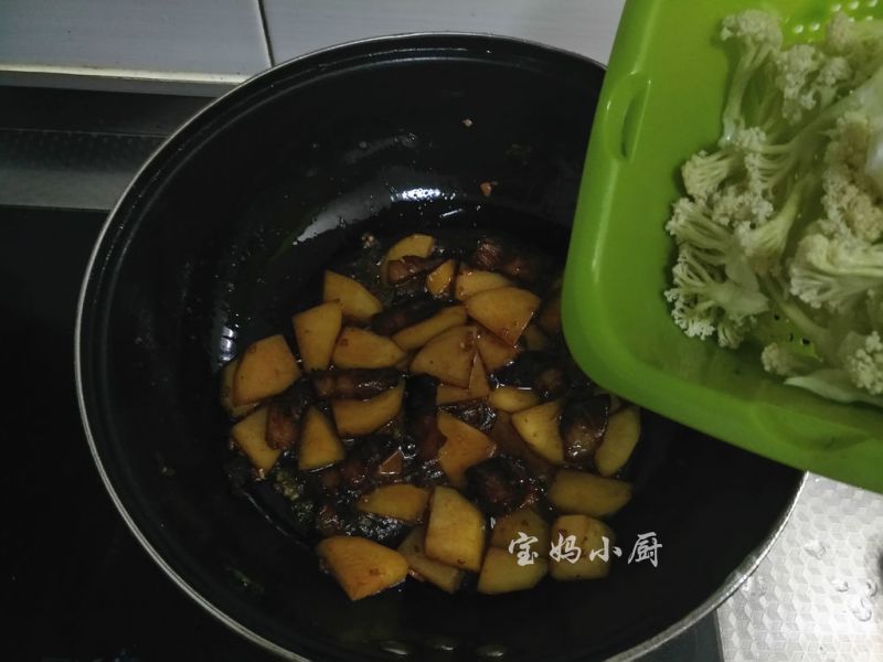 土豆烧菜花的做法操作步骤第7步：炒到土豆断生，放入菜花煸炒到菜花颜色变深