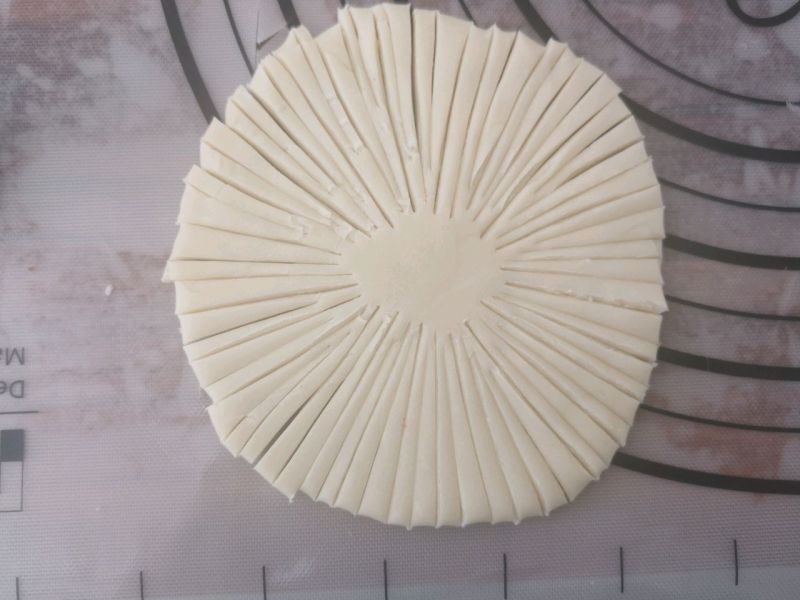酥皮点心的做法操作步骤第9步：把剂子擀成圆形，切割成丝状，中间留白的直径大概1.5厘米。切割的方式可以先分割成四等份，然后再切割成小条。