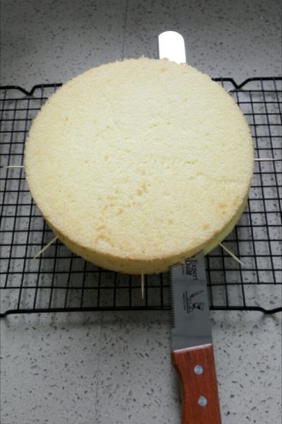 水果奶油裱花蛋糕的做法操作步骤第14步：蛋糕完全晾凉后，从中间横切面剖开，可以在侧面要下刀的地方平均插8根牙签，顺着牙签下刀，不会切薄厚不均。当然有蛋糕切片器的或者熟练以后就可以直接切了