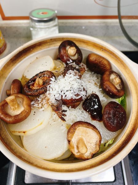 香菇萝卜煲的做法操作步骤第4步：砂锅里放萝卜和白菜，香菇连水倒入，加大米和上述调料。