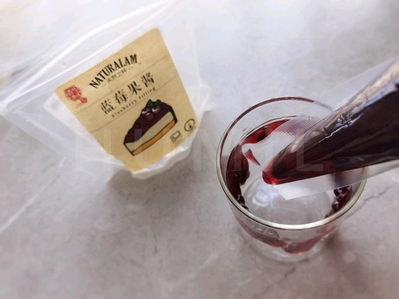 蓝莓脏脏茉莉奶绿的做法操作步骤第2步：取一个杯子，将蓝莓果酱绕着杯壁挤一圈