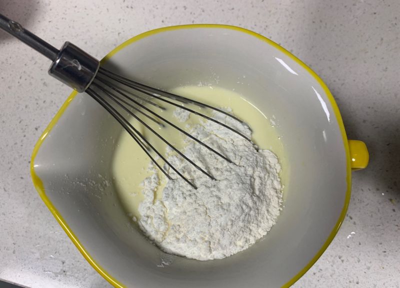 舒芙蕾的做法操作步骤第5步：融化好的奶酪液体中放入低筋面粉，搅拌至无颗粒