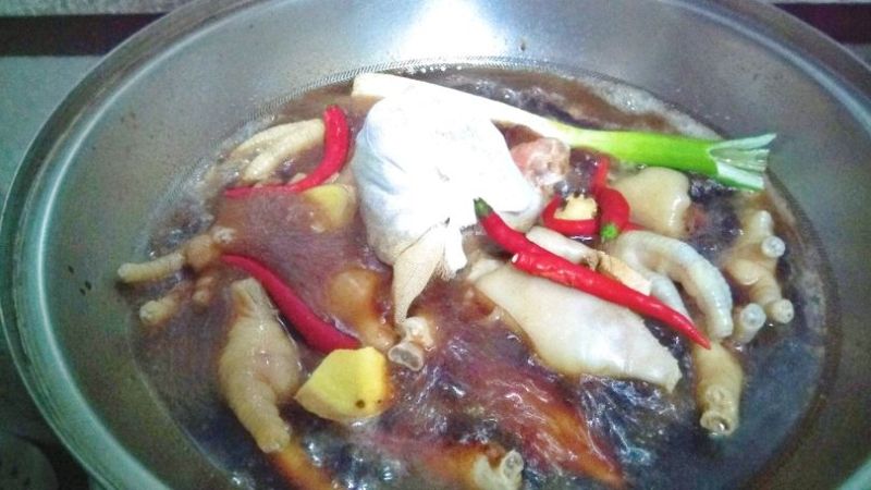 卤味拼盘的做法操作步骤第10步：先放如处理好的猪蹄，鸡爪，葱姜，辣椒，中药包煮开锅