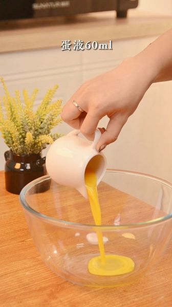 蔓越莓司康的做法操作步骤第4步：另外拿一个玻璃碗倒入蛋液60毫升，牛奶60毫升搅拌均匀