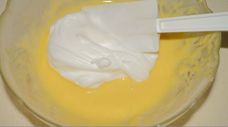 奶油戚风蛋糕卷的做法操作步骤第8步：取三分之一蛋白糊入蛋黄糊中，上下轻轻地翻拌均匀