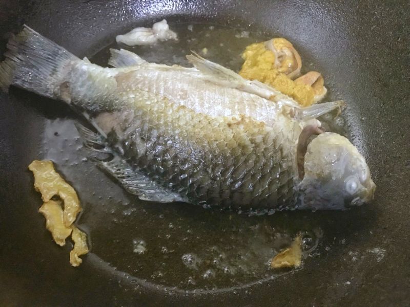 鲫鱼豆腐汤的做法操作步骤第4步：鲫鱼煎好后翻面煎。这样做的好处是把鱼皮保持完整，鱼肉煮好保持紧致口感不散开。