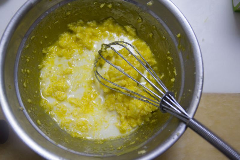 黄金能量球—椰蓉麦片球的做法操作步骤第3步：加入蛋黄液，搅拌均匀；倒入牛奶，继续搅拌；
