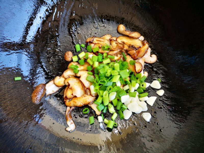 香菇尖椒炒豆皮的做法操作步骤第5步：加入葱蒜炒香。