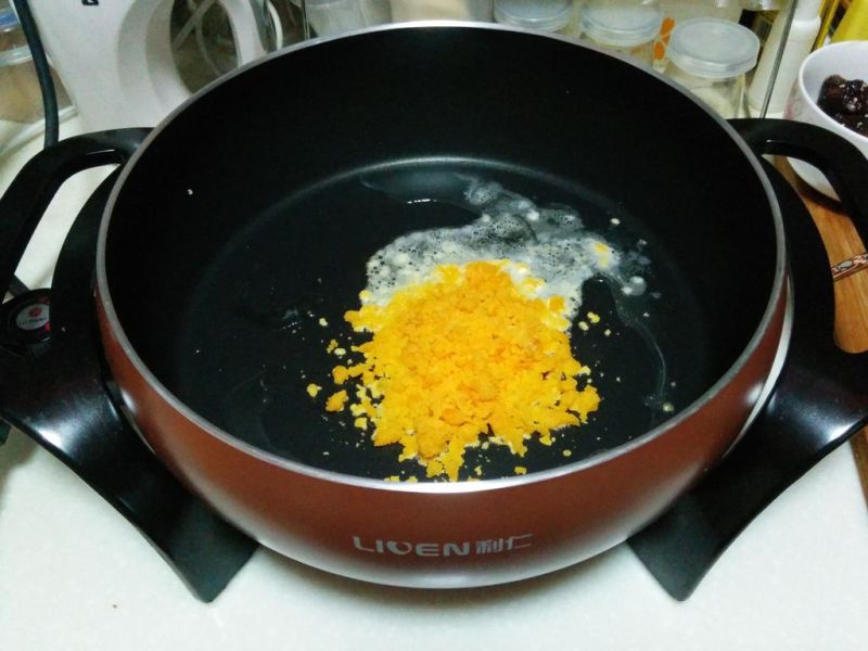 咸蛋黄焗南瓜的做法操作步骤第7步：锅内倒入少许油，烧热后倒入碾成泥的蛋黄