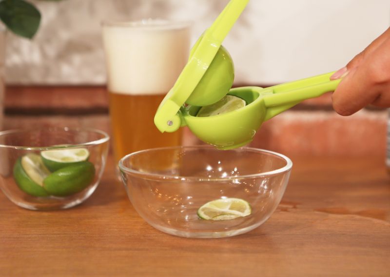 花式啤酒的做法操作步骤第4步：用榨汁器榨取青柠汁，倒入杯中。