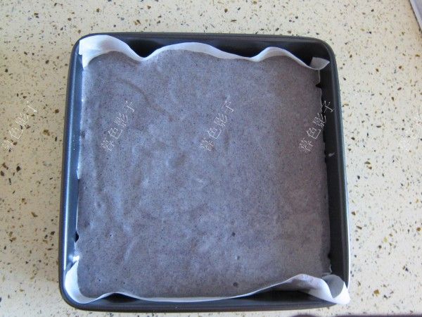 黑米粉方块蛋糕的做法操作步骤第8步：蛋糕糊全部倒进模具。端起来磕几下震出气泡（此时预热烤箱180度5分钟。）