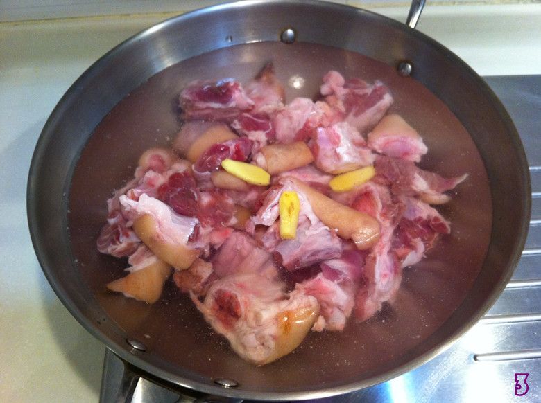 风味辣猪蹄的做法操作步骤第3步：冷水锅，下猪脚及部分姜片，盖上盖子煮；