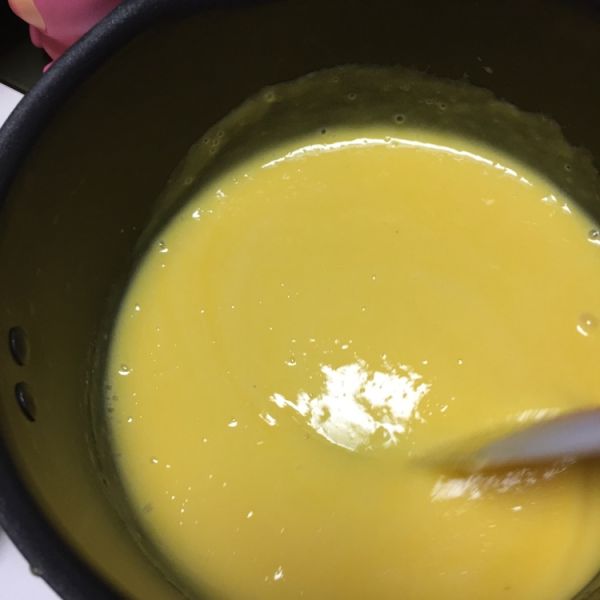 芒果慕斯蛋糕的做法操作步骤第6步：300g芒果泥倒入奶锅中搅拌均匀，记得留50g左右的芒果泥备用