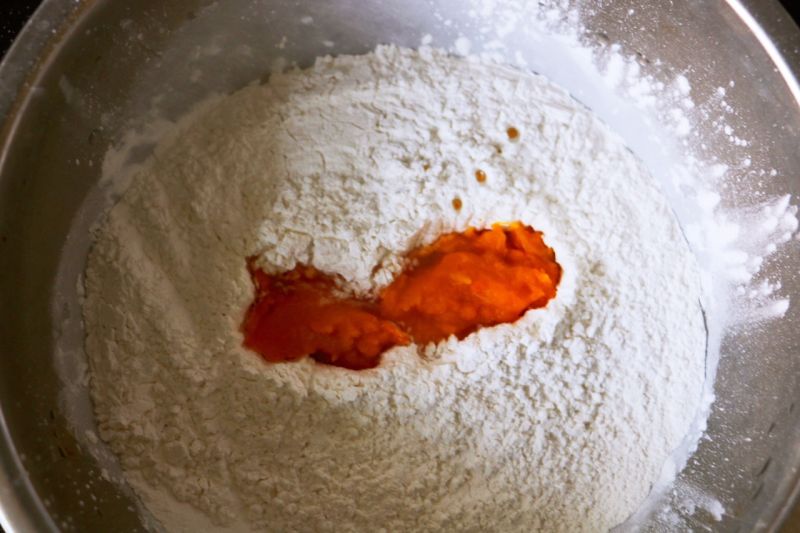 南瓜豆沙小点心的做法操作步骤第2步：将蒸熟的南瓜碾碎放入糯米粉。