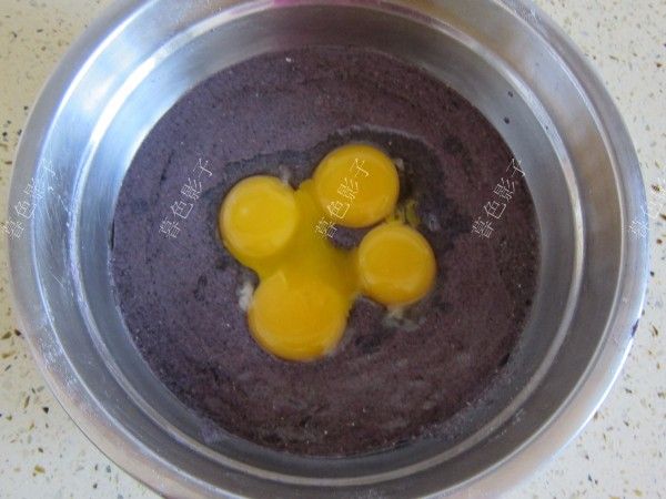 黑米粉方块蛋糕的做法操作步骤第3步：将鸡蛋黄放进黑米糊的容器里，手动搅到完全融合，而且没有颗粒成为蛋黄糊备用。