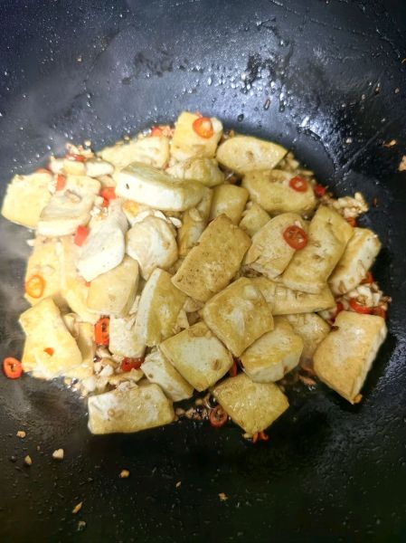 家常豆腐的做法操作步骤第3步：起锅烧油，倒入蒜末、小米辣炒出香味，倒入豆腐