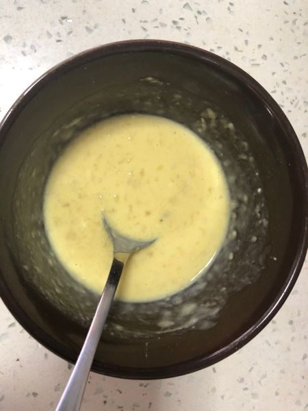 黄油香蕉松饼的做法操作步骤第2步：碗中打入一个鸡蛋打散 加入牛奶和面粉 以及压好的香蕉泥 搅拌均匀至无干粉状态