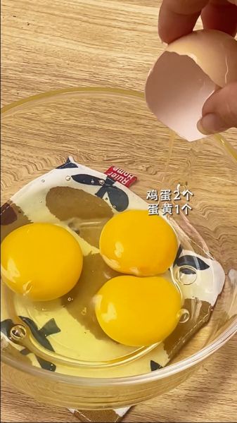 巴斯克芝士蛋糕的做法操作步骤第2步：用一个玻璃碗把2个鸡蛋，1个蛋黄打进去，打散