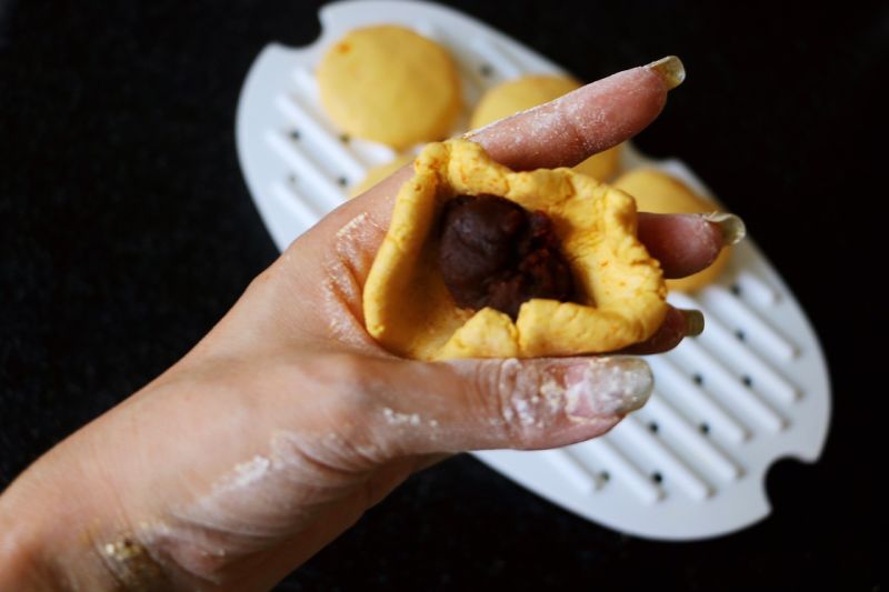 南瓜豆沙小点心的做法操作步骤第5步：每个小糯米饼依次加入豆沙馅，封口揉实。