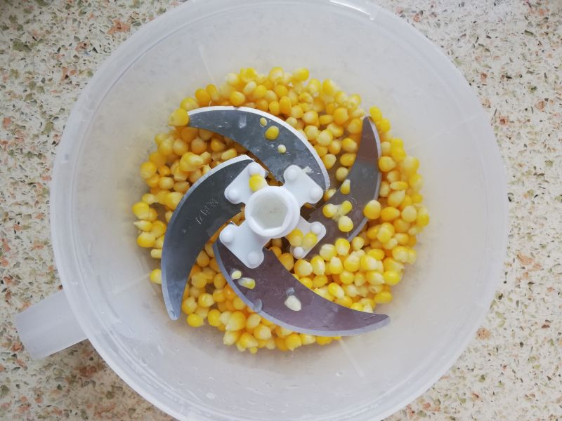 虾仁别再炒着吃了，这样做，当早餐大人孩子都爱吃的做法操作步骤第9步：将焯好水的玉米粒倒入绞肉器里，绞碎