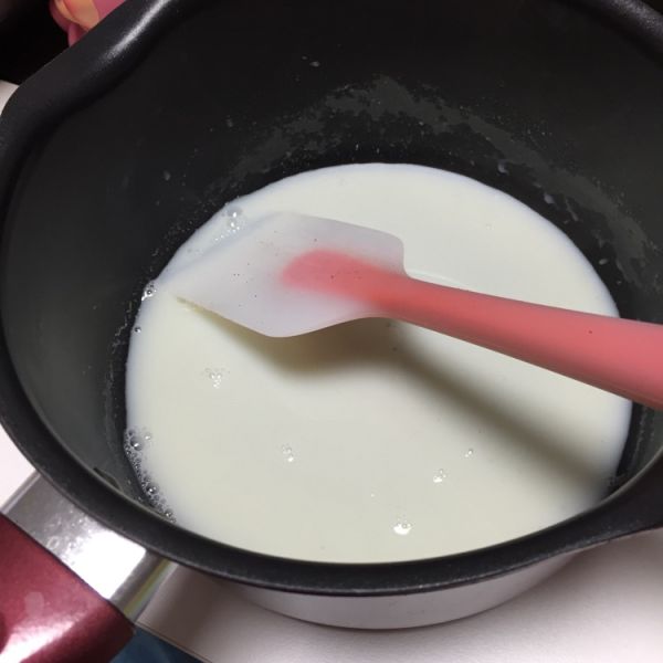 芒果慕斯蛋糕的做法操作步骤第5步：剩下的牛奶和砂糖倒入奶锅，小火溶化后即可关火放入吉利丁片搅拌溶化
