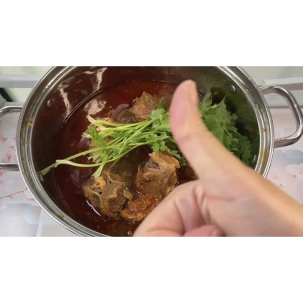 羊蝎子火锅的做法操作步骤第15步：压好后，倒进打火锅的大锅里，撒上一小把香菜，就可以啦！