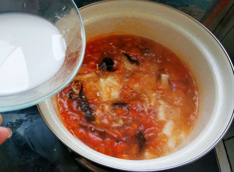 懒人开胃酸辣汤，西红柿的另类打开方式的做法操作步骤第11步：等再次开锅即可加入水淀粉，边加边搅匀，这样能使汤更浓郁。