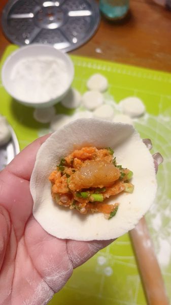 海胆虾仁水饺的做法操作步骤第4步：擀好的饺子皮包馅，每个都放一块虾仁肉